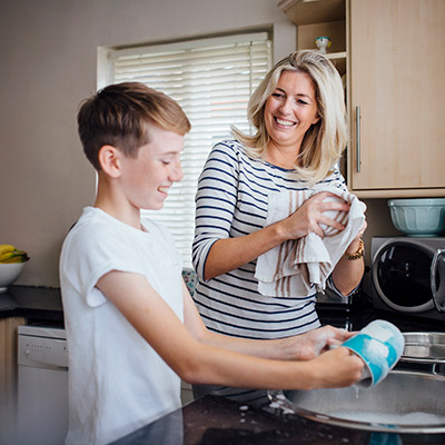 Young Man Helping Mother With Dishes